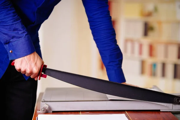 Close up of man working on the guillotine, cutting paper — Stock Photo, Image