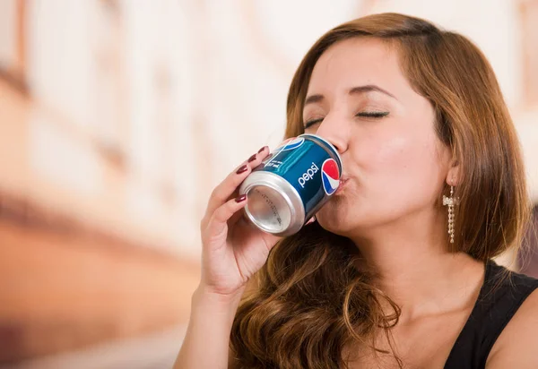 Quito, Ecuador Mayo, 06, 2017: Mujer joven y guapa bebiendo pepsi en el fondo borroso de la ciudad — Foto de Stock