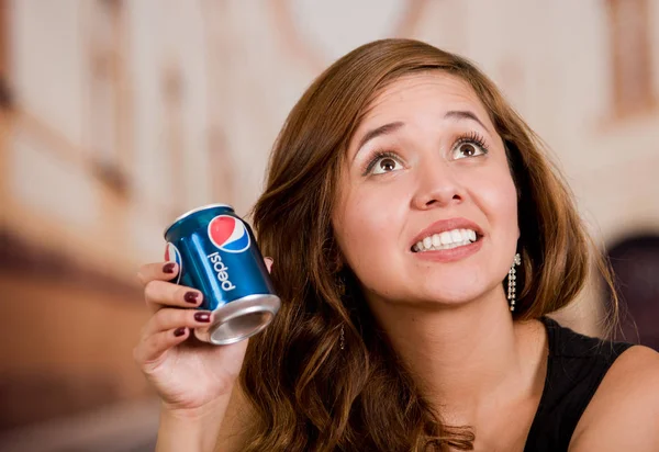 Quito, Équateur May, 06, 2017 : Une jeune femme souriante tenant un pepsi dans un contexte urbain flou — Photo