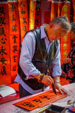 Shenzen, Çin - 29 Ocak, 2017: Çinli siyah harflerle kırmızı afiş, arka planda, Çin yeni yılı kutlama kavramı asılı birkaç afiş resim