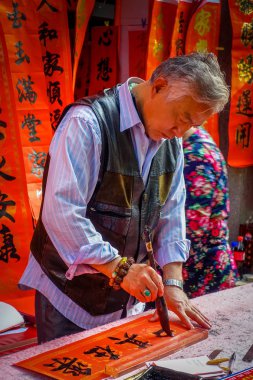 Shenzen, Çin - 29 Ocak, 2017: Çinli siyah harflerle kırmızı afiş, arka planda, Çin yeni yılı kutlama kavramı asılı birkaç afiş resim