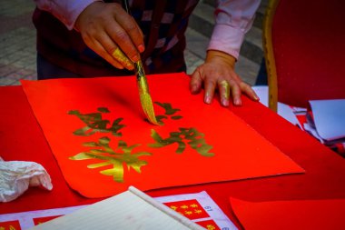 Shenzen, Çin - 29 Ocak, 2017: adam Çin yeni yılı için hazırlanıyor altın harflerle kırmızı dekoratif afiş resim