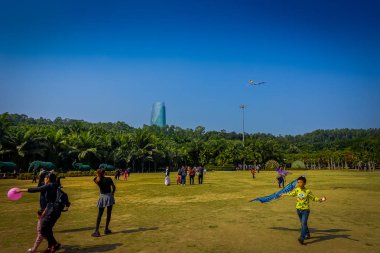 Shenzen, Çin - 29 Ocak, 2017: Lian Hua Shan içinde park, büyük rekreasyon alanı, uçurtma, güzel mavi gökyüzü ve uzun boylu ağaçlar yukarıda arka planda bina oynamaya çim üzerinde çalışan insanlar