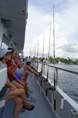 Fort Lauderdale, Amerika Birleşik Devletleri - 11 Temmuz 2017: Fort Lauderdale, Florida büyük tekneler balıkçılık çubuklar önünde otururken kimliği belirsiz kişi