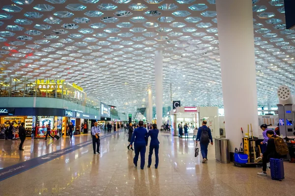 深セン, 中国 - 2017 年 1 月 29 日: 空港ターミナルの接続ホール、モダンなインテリア デザイン、内ガラス混合白いパネル、ショップやレストラン、周辺の人々 — ストック写真