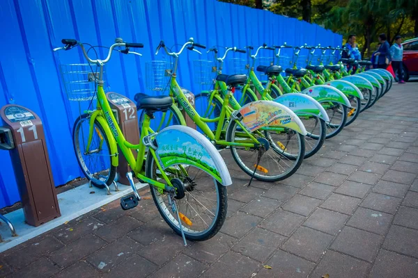SHENZEN, CHINA - 29 JANUARY, 2017: City bike parking, row of green bikes connected to automatic machines on city street — Stock Photo, Image