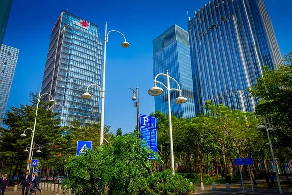 Shenzhen, Kina - 29 januari 2017: innerstadens gator och sorroundings, vacker blandning av gröna träd kombineras med byggnader, modern arkitektur, lätt trafik, helt blå himmel — Stockfoto