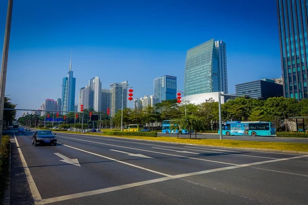 SHENZEN, CHINA - 29 ENERO 2017: Calles interiores y alrededores, hermosa mezcla de árboles verdes combinados con edificios, arquitectura moderna, tráfico ligero, cielos totalmente azules — Foto de Stock