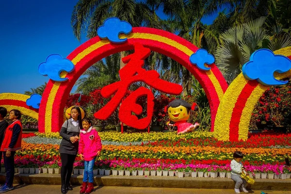 SHENZEN, CHINA - 29 ENERO 2017: Hermoso arreglo floral dentro del parque Lian Hua Shian, turistas posando en frente — Foto de Stock