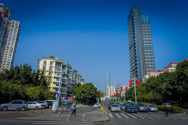 SHENZEN, CHINA - 29 ENERO 2017: Barrio Nan Shan, calles del centro de la ciudad y alrededores, hermosa mezcla de árboles verdes combinados con edificios, arquitectura moderna, tráfico ligero, totalmente azul —  Fotos de Stock