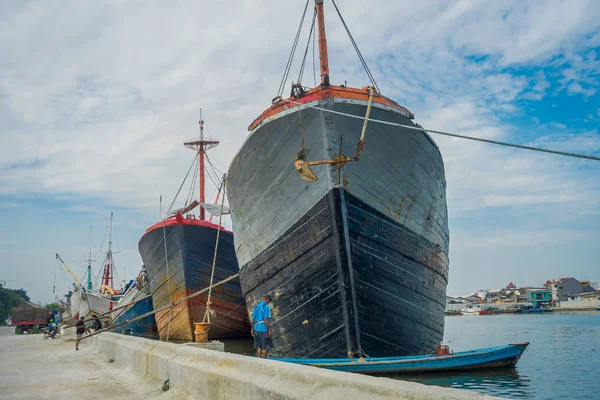 JAKARTA, INDONÉSIA - 5 DE MARÇO DE 2017: Atividades diárias dentro da famosa área portuária de Jacarta, barcos de pesca, pescadores, guindastes e caminhões que trabalham em um belo dia ensolarado — Fotografia de Stock