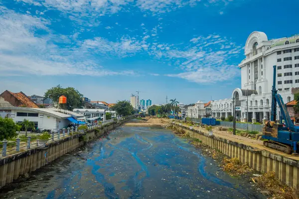 JAKARTA, INDONÉSIA: Charming water channel passing through Jakarta seen from bridge, residence buildings along. belo céu azul — Fotografia de Stock