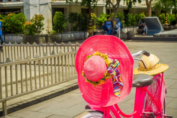 JAKARTA, INDONESIA: Sombrero rosa colocado en bicicleta estacionado frente al museo de historia de Yakarta en un hermoso día soleado — Foto de Stock