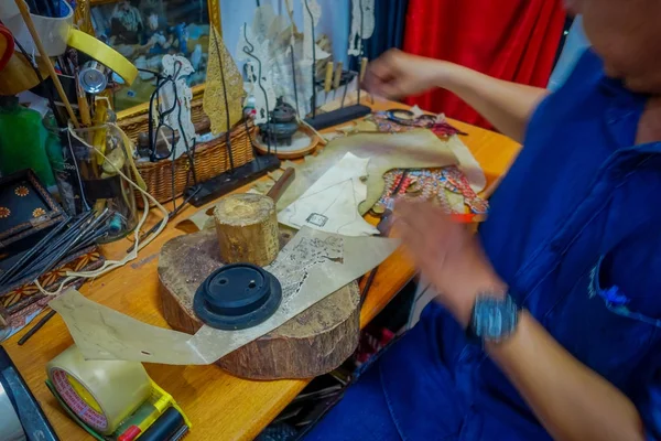 Jakarta, indonesien: einheimischer handwerker sitzt am arbeitstisch und schafft mit seinen werkzeugen traditionelle kunst — Stockfoto