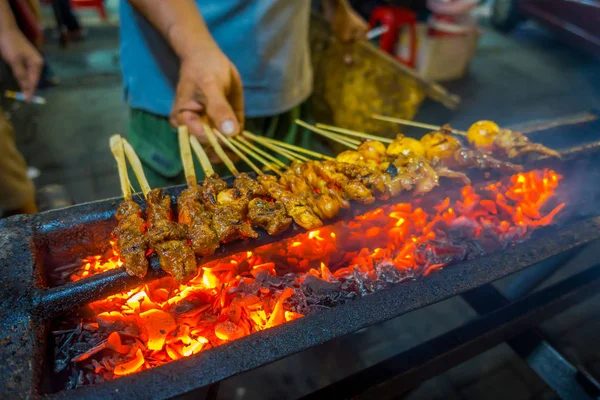 Jakarta, Indonesië: Street barbecue met vleesspiesen sissende, zeer heet vuur branden en man bereiden van voedsel — Stockfoto
