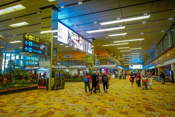 AEROPUERTO DE SINGAPUR - 7 DE MARZO DE 2017: Caminando alrededor de la zona de traslado de llegada en el aeropuerto de Singapur, los viajeros dispersos —  Fotos de Stock