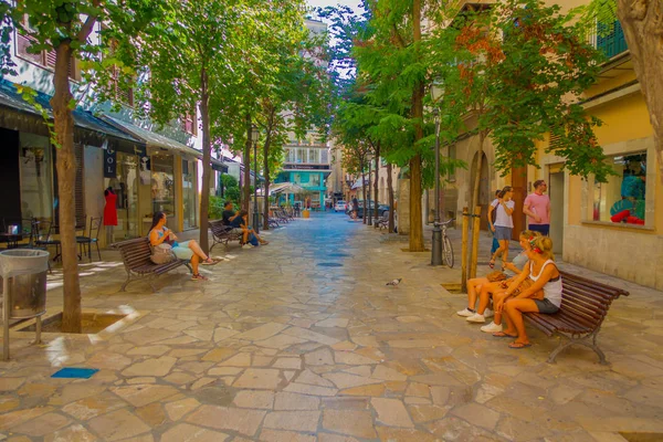 PALMA DE MALLORCA, ESPAÑA - 18 DE AGOSTO DE 2017: Personas no identificadas sentadas en sillas públicas mientras otros turistas siguen caminando por el Boulevard Born en Palma de Mallorca, España, Europa — Foto de Stock