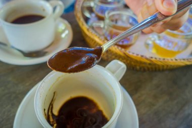 El bir kaşıkla bir Kopi Luwak kahve Bali, Endonezya, çiftliğinde ahşap arka plan ekleme