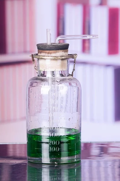 Primo piano di un laboratorio medico, con un barattolo di laboratorio con un liquido verde all'interno pronto per i campioni di test di biologia chimica, esaminando liquidi, attrezzature, ricerca scientifica e sanitaria — Foto Stock