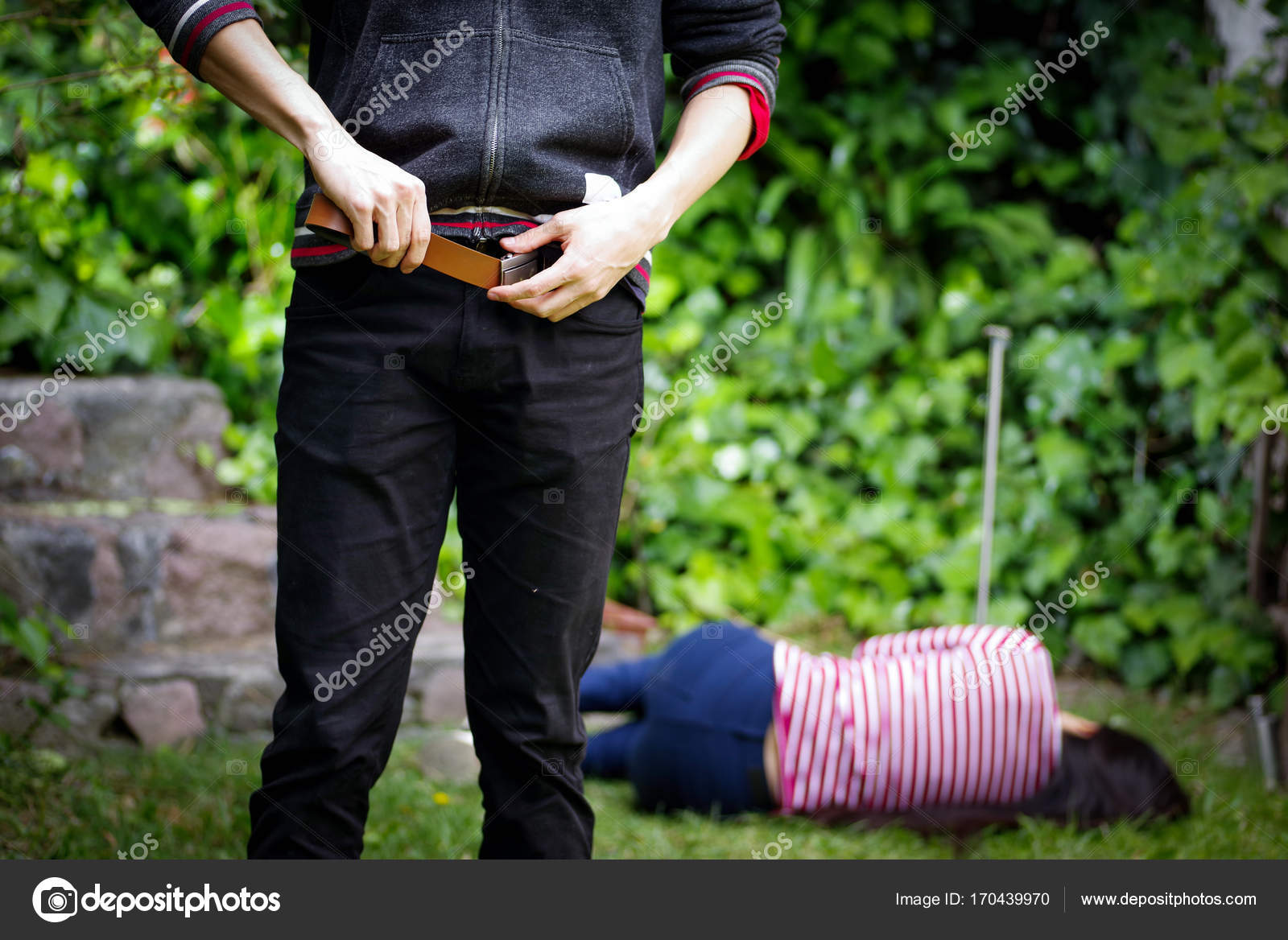 性的虐待後、婦女暴行者の背後の地面に敷設の女性と彼のズボンを調整する人間のクローズ アップ。強姦および性的虐待の概念 — ストック写真 ©