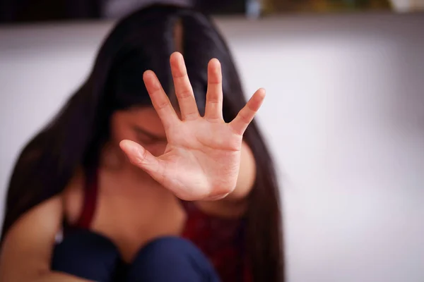 Primo piano di una giovane donna che punta la mano aperta davanti a lei dopo essere stata violentata e aver subito abusi sessuali, in uno sfondo sfocato — Foto Stock