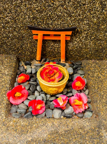 Close-up de um conjunto de flores vermelhas cattleya orquídea e pedra como oblação sobre um chão apedrejado no Japão — Fotografia de Stock