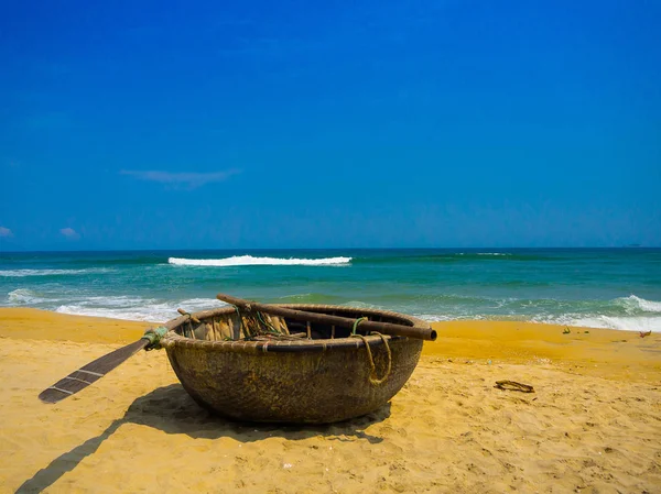 Piękny, słoneczny dzień z drewnianą łodzią na żółty piasek w pandawa beach Pantai, na wyspie Bali, Indonezja — Zdjęcie stockowe