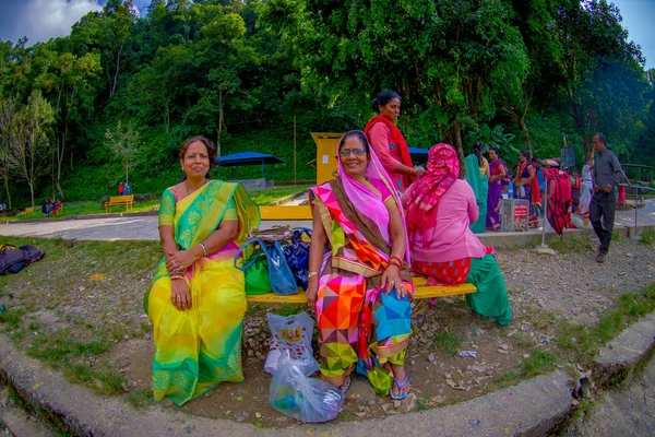 POKHARA, NEPAL - 04 DE NOVIEMBRE DE 2017: Grupo no identificado de mujeres sentadas en un lugar público esperando y vistiendo ropa típica cerca del lago Begnas en Pokhara, Nepal, efecto ojo de pez —  Fotos de Stock