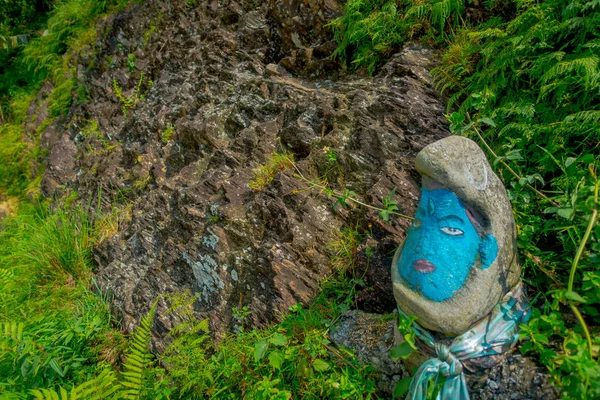 ПОХАРА, НЕПАЛЬ - 04 НОЯБРЯ 2017 г.: Закрыть камень, окрашенный в синий цвет в земле, внутри леса в Похаре, Непал — стоковое фото
