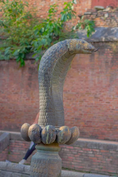 POKHARA, NEPAL - 04 DE NOVIEMBRE DE 2017: Primer plano de la antigua estatua de serpiente de bronce oxidado ubicada cerca de un templo en Pokhara, Nepal —  Fotos de Stock