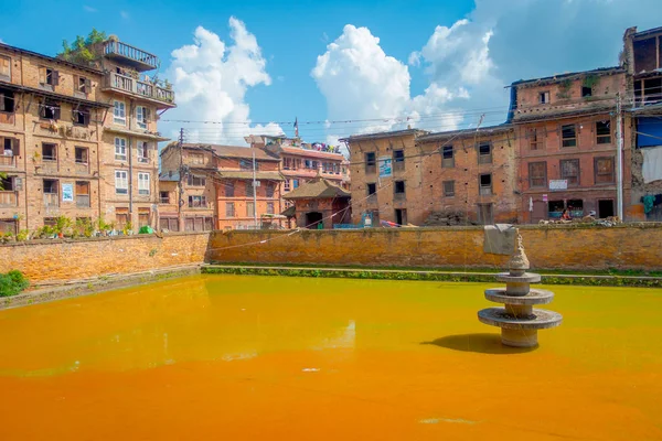 BHAKTAPUR, NEPAL - NOVEMBRO 04, 2017: Fechar a cena urbana tradicional com uma lagoa artificial de água amarela na cidade de Bhaktapur, Nepal — Fotografia de Stock