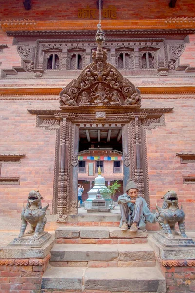 BHAKTAPUR, NEPAL - NOVEMBRO 04, 2017: Homem não identificado sentado no entrada do antigo templo hindu na praça Durbar em Bhaktapur, esta é a cidade com mais templos para a área — Fotografia de Stock