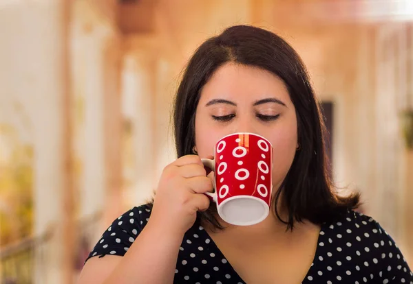 Ritratto di bella donna grassa in un bel vestito, dra tazza di caffè in uno sfondo sfocato — Foto Stock