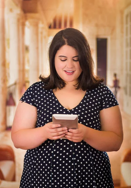 Close up of beautiful fat woman in a beautiful dress using her tablet in a blurred background — Stock Photo, Image