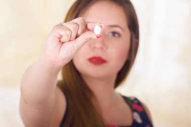 Onun elinde tutan bir yumuşak, jelatin Vajinal tablet veya fitil, kadın sağlık önlenmesi ve kadın üreme organları hastalıkları tedavisi genç bir kadın portresi