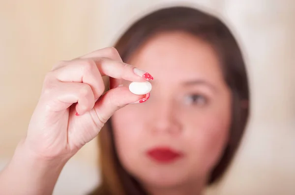Portrait of a young woman holding in her hand a soft gelatin vaginal tablet or suppository, treatment of diseases of the reproductive organs of women and prevention of womens health — Stock Image Portrait of a young woman holding in her hand a soft gelatin vaginal tablet or suppository, treatment of diseases of the reproductive organs of women and prevention of womens health Stock Picture