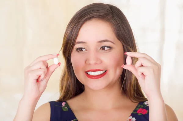 Portrait of a smiling woman holding in both hands a soft gelatin vaginal tablet or suppository, treatment of diseases of the reproductive organs of women and prevention of womens health, in a blurred — Stock Image Portrait of a smiling woman holding in both hands a soft gelatin vaginal tablet or suppository, treatment of diseases of the reproductive organs of women and prevention of womens health, in a blurred Stock Image