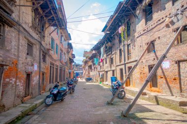 BHAKTAPUR, Nepal - 04 Kasım 2017: Motrcycles eski ve kirli, açık park etmiş olan bazı binalar Bhaktapur, Nepal'de yer alan eski tuğla ile rustik bir kasabada sokak