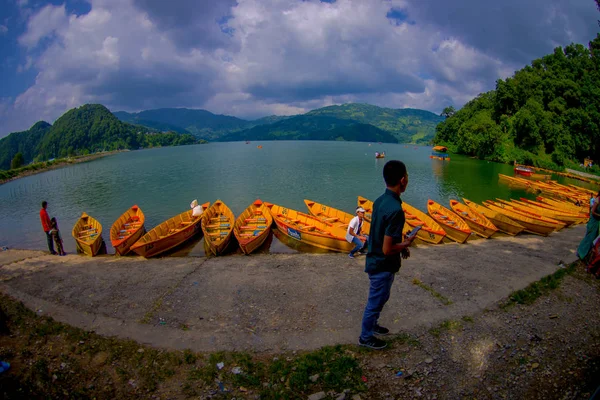 POKHARA, NEPAL - 04 DE NOVIEMBRE DE 2017: Personas no identificadas en la frontera del lago con botes de madera en fila en el lago Begnas en Pokhara, Nepal —  Fotos de Stock