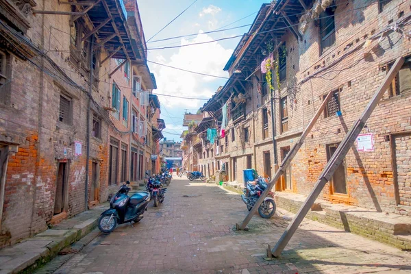 BHAKTAPUR, NEPAL - NOVEMBER 04, 2017: Motrcycles parked at outdoor in old and dirty street in a rustic town, with some buildings with old bricks located in Bhaktapur, Nepal — Stock Photo, Image