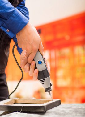 Ahşap bir çerçeve ile aksesuar arka plan bulanık gri bir tablo üzerinde sondaj ile onun matkap sondaj bir hardworker adam closeup