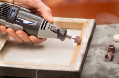Arka plan bulanık gri bir tablo ahşap bir çerçeve içinde bir Parlatıcı kullanan bir hardworker adam closeup