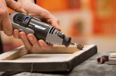 Arka plan bulanık gri bir tablo ahşap bir çerçeve içinde bir Parlatıcı kullanan bir hardworker adam closeup
