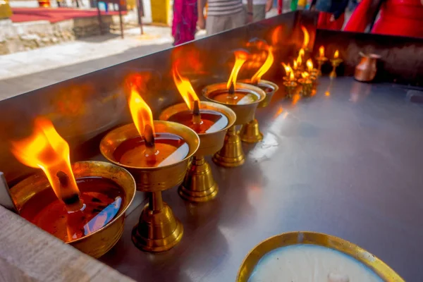 Close up van brandende kaarsen binnen gouden goblets in een tempel. Kathmandu, Nepal, Asia — Stockfoto