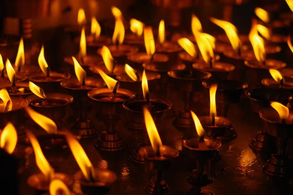 Velas ardiendo en la oscuridad dentro del templo. Katmandú, Nepal, Asia —  Fotos de Stock