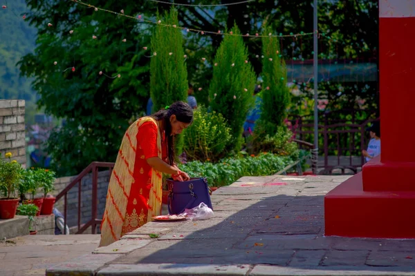 KATHMANDU, NEPAL - 04 DE SEPTIEMBRE DE 2017: Mujeres no identificadas revisando su bolso púrpura al aire libre cerca del templo Bindabasini, es de gran importancia religiosa para los hindúes locales —  Fotos de Stock