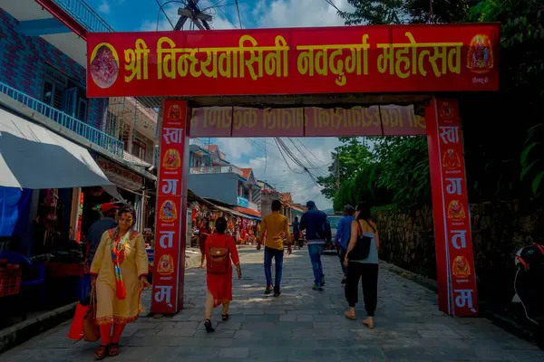 尼泊尔加德满都-2017年9月4日: 在尼泊尔加德满都的一个红色巨大的信息标志下, 身份不明的人走在早市。早市市场位于安娜普尔纳寺庙附近。 — 图库照片