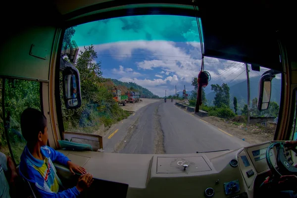 POKHARA, NEPAL 10 DE OCTUBRE DE 2017: Primer plano de un niño pequeño con un conductor de autobús en la cabina que conduce un camión en la carretera en las calles, ubicado en Pokhara, Nepal — Foto de Stock