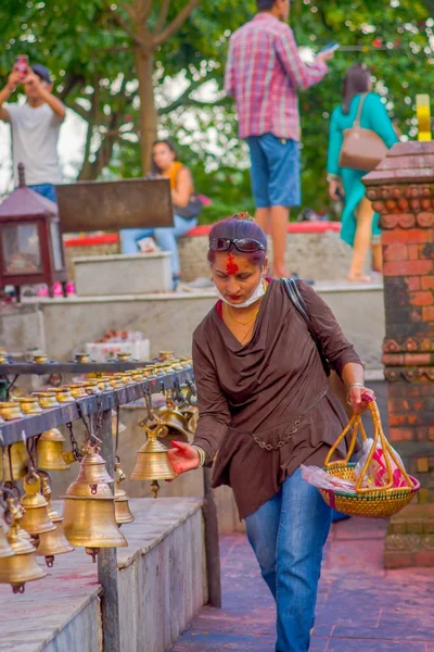 POKHARA, NEPAL 10 DE OCTUBRE DE 2017: Joven no identificado tocando las campanas de diferentes tamaños colgadas en el templo Taal Barahi Mandir, Pokhara, Nepal —  Fotos de Stock