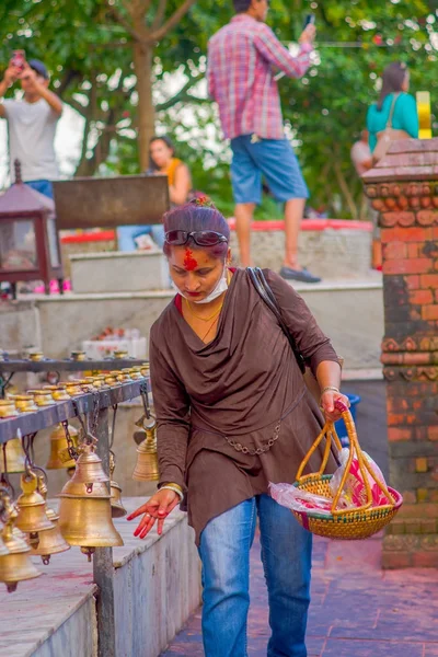 POKHARA, NEPAL 10 DE OCTUBRE DE 2017: Joven no identificado tocando las campanas de diferentes tamaños colgadas en el templo Taal Barahi Mandir, Pokhara, Nepal —  Fotos de Stock